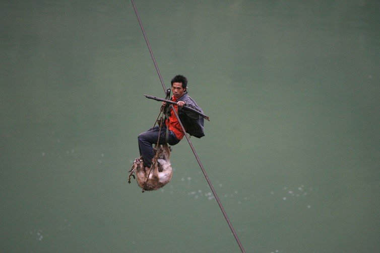 A man and his goat cross over the Nu River on a cable, near Lushui southwest China’s Yunnan province.