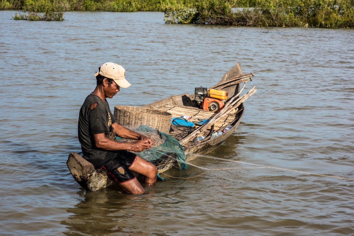 Fisherman checking his net, Cambodia