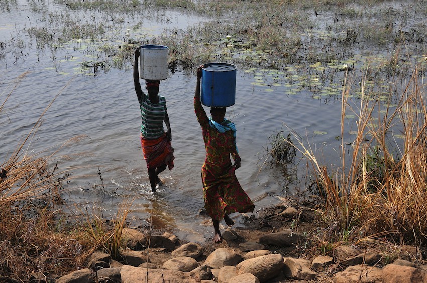 Women collect water in west Africa