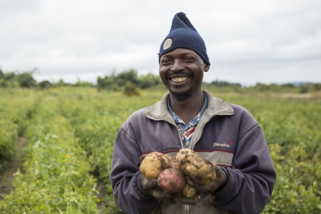 A farmer showing potatoes he has grown in a village near Iringa, Tanzania.
