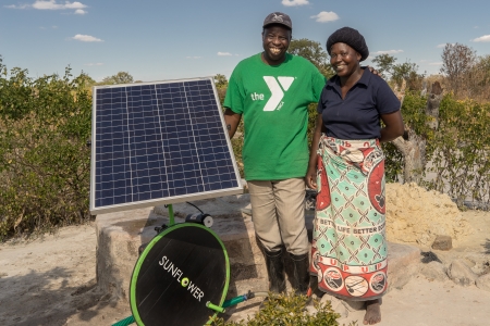 Kenyan farmers posing with a solar irrigation pump.
