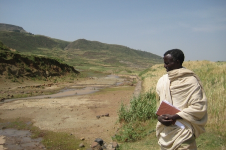 A man looks onto a dried out stream during a drought in Ethiopia.