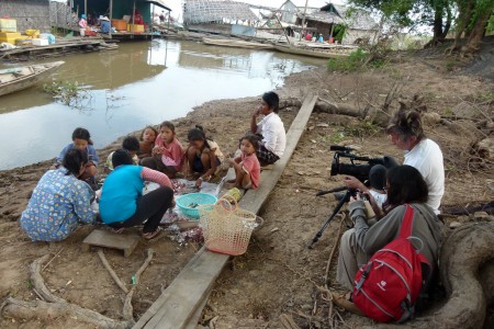 Douglas Varchol films while women clean fish. Tonle Sap, Cambodia.