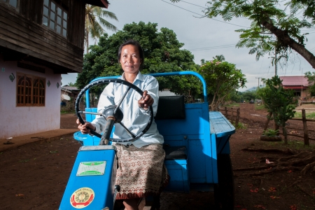 A female farmer demonstrating the tractor she bought with funds from cassava.