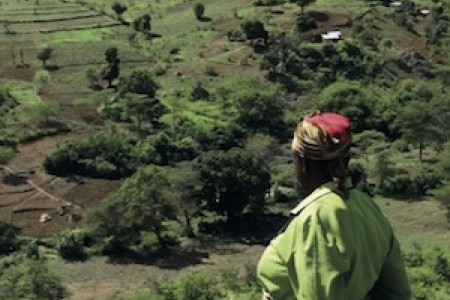 Woman overlooking Kitui agricultural landscape, Kenya.