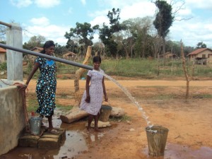 The women smile with happiness as water flows from the tank
