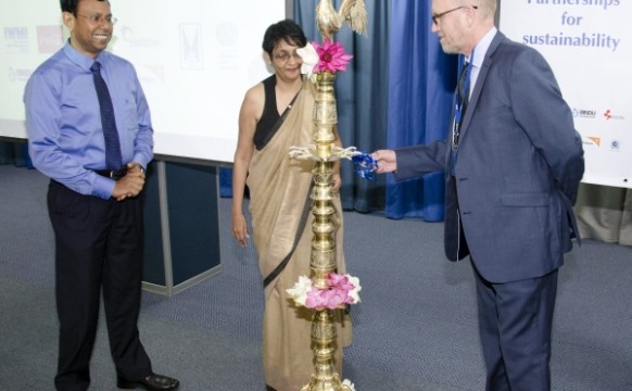 Dr Peter McCornick of IWMI lights the lamp at the start of the  dialogue with Dr Ananda Mallawatantri of IUCN and Shyama Salgado of ILO