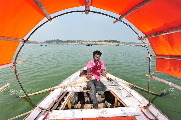 A tourist boat operator at Sangam where the Ganges river meets the Yamuma. 