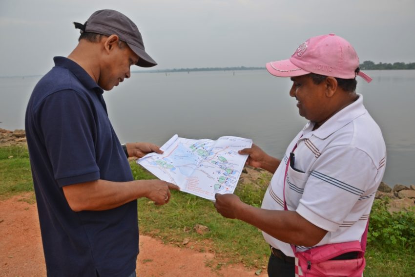 Lal Muthuwatta (left), IWMI researcher, and Premachandra Wickrama Waththage, IWMI Field Coordinator, go through a map of a tank cascade system in the Malwathu Oya River Basin.