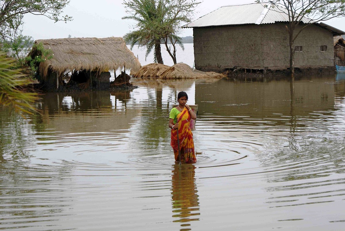 Flood Waters and Daily life - lady trying to reach home. Photo: Anil Gulati - India Water Portal