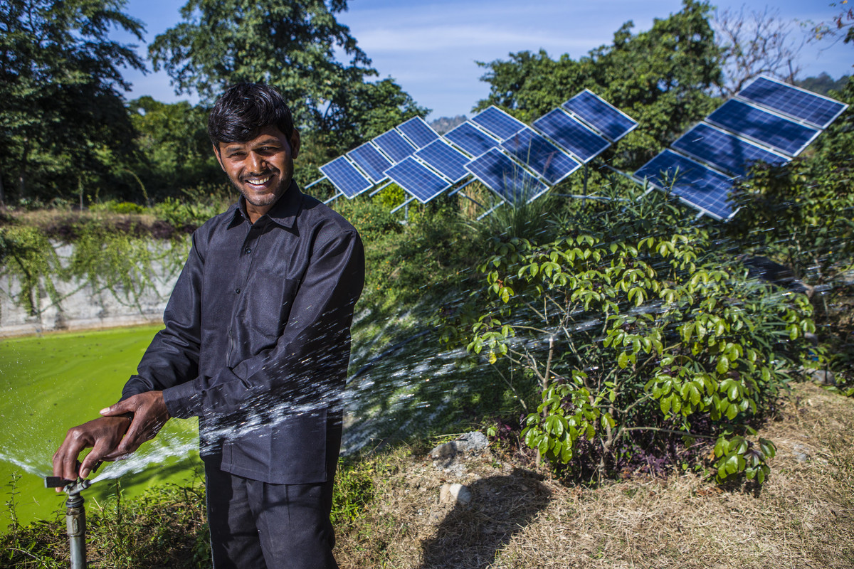 24 years old Mohan Das works on a sprinkling system energized through a submerged solar pump at a private farm in Klashar.