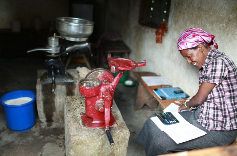A woman at a dairy cooperative does her accounting. Bringing relevant actors—including private sector companies—together can help bridge fragmented efforts and create opportunities. Irrigation, for example, helps farmers grow fodder to feed cattle, which facilitates dairy production. A strong linkage between irrigation suppliers, fodder irrigators and dairy producers and processors means business opportunities across the market and resilience against shocks like climate-related floods and droughts as well as COVID-19. Photo credit: Apollo Habtamu/ILRI