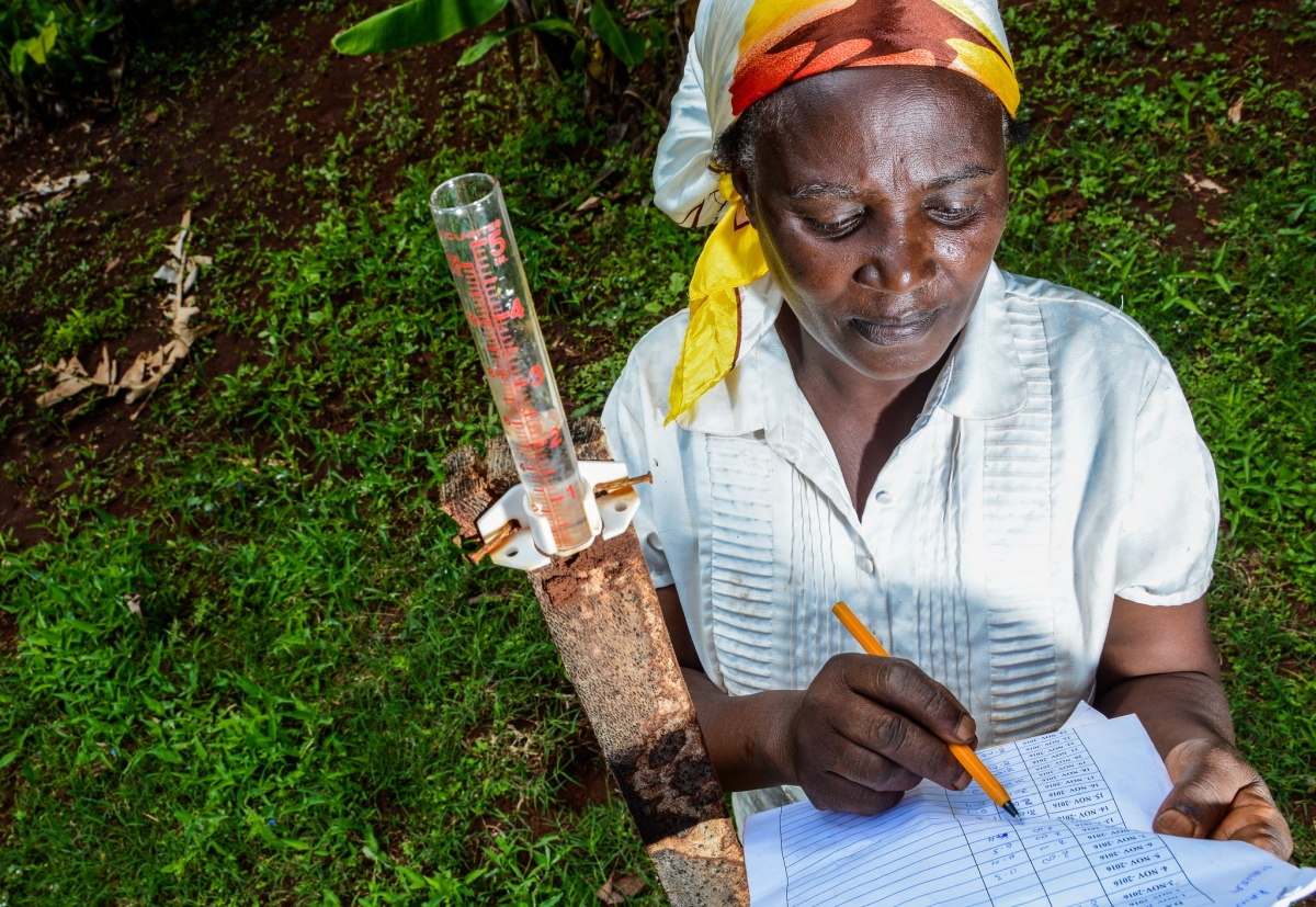 Farmer Mercy Wambui measuring rain water on her farm. Photo: CIAT / Georgina Smith