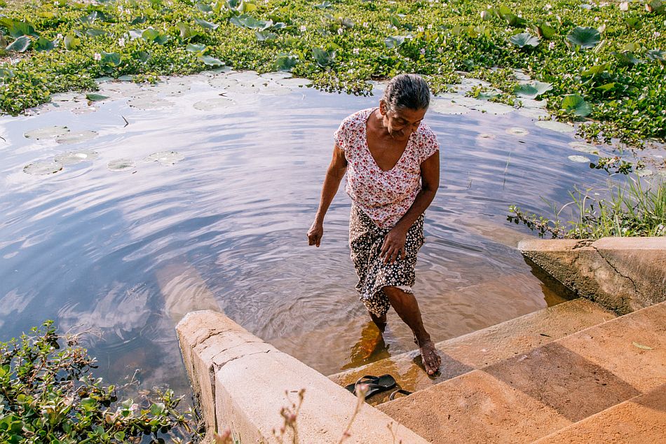 Woman washing her feet after her daily chores, at the Anawilundawa lake in Sri Lanka. Photo: Shaoyu Liu / IWMI