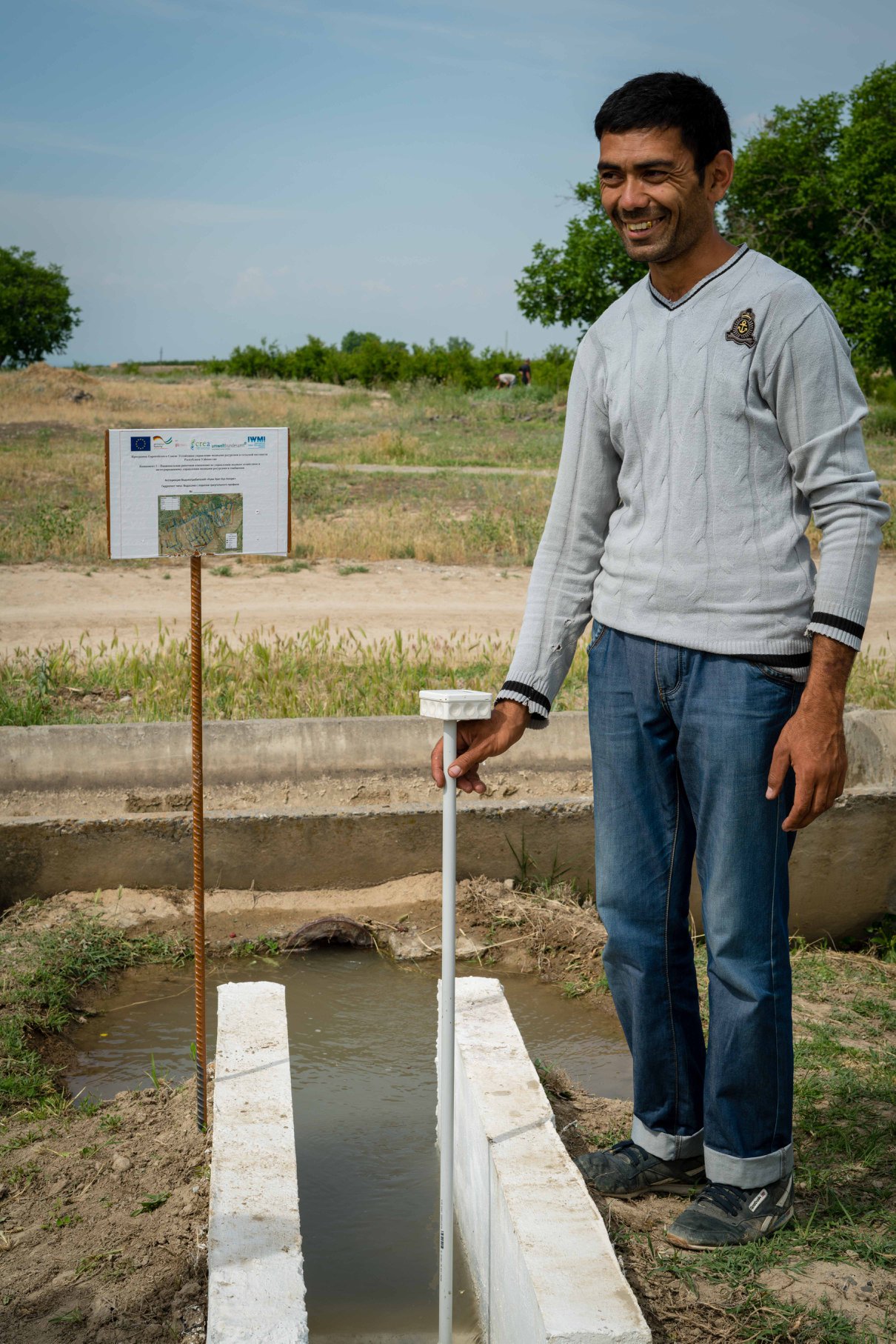 WCA Hydrotechnician Kuva Urta Buz Anori  measures water discharge with a Smartstick. Kuva District, Ferghana Province, Uzbekistan