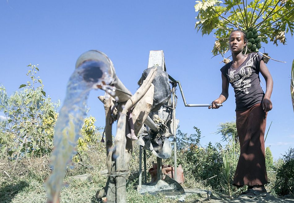Using the rope pump to fetch water. Photo: Petterik Wiggers / IWMI